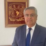 رجل يرتدي بدلة غامقة يتحدث في مناسبة رسمية.