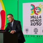 رجل يلقي كلمة على منصة وخلفه شعار "يلا فاموس 2030".
