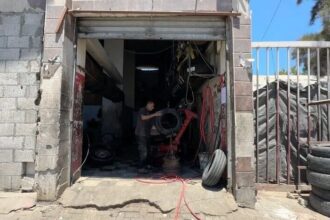 رجل يصلح إطار سيارة بأساليب بدائية