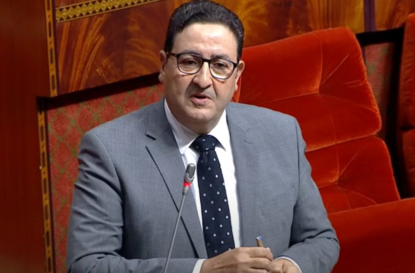 رجل يرتدي نظارة وربطة عنق يتحدث في مؤتمر.