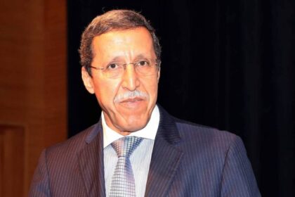 رجل يتحدث أمام خلفية باللون البني