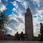 شخصان يجلس أحدهما على كرسي والآخر يمشي