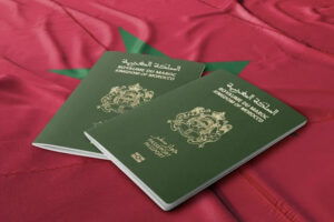 جواز سفر مغربي أخضر يحمل العلم فوق قطعة قماش.