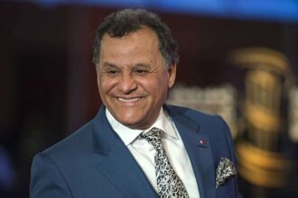 المهدي قطبي يرتدي بدلة داكنة وربطة عنق مبتسماً