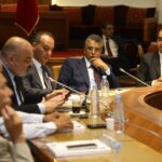 لقطة لمجموعة من الرجال ببدلات رسمية خلال اجتماع عمل
