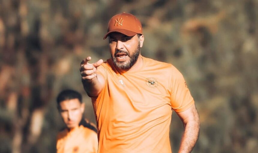 معين الشعباني يشير بيده في الزي البرتقالي
