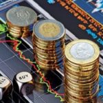 أوراق نقدية ودولار وقطع معدنية مع رسم بياني