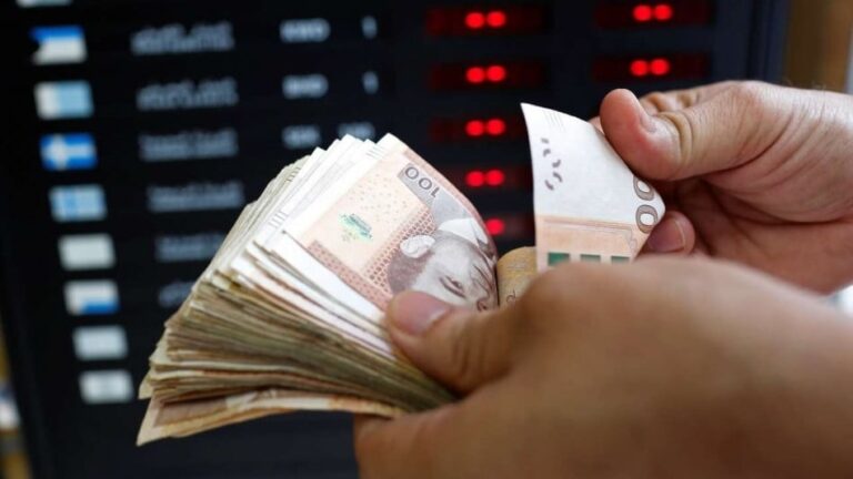 شخص يحمل نقودًا ورقية من عملات مختلفة