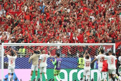 مشجعون مغاربة يحملون الأعلام في ملعب رياضي