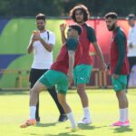 لاعب كرة قدم مغربي يتدرب بزي أحمر وأخضر