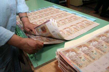 أوراق مالية وأيدٍ تحمل نقوداً.