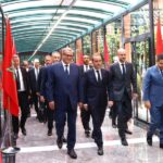 رئيس المغرب بجوار رئيس أساقفة الرباط يحدقان في الممر