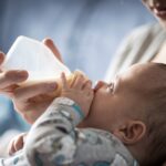 أم تطعم طفلها الرضيع من زجاجة الحليب