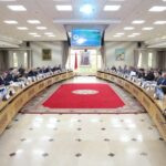 رجال في قاعة اجتماعات عامة مع سجاد أحمر