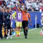 حكم يرفع بطاقة صفراء للاعب كرة قدم