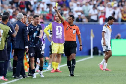 حكم يرفع بطاقة صفراء للاعب كرة قدم