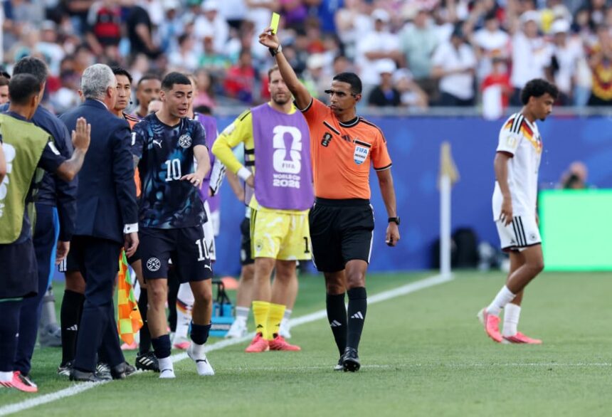 حكم يرفع بطاقة صفراء للاعب كرة قدم