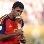 رودري يحتفل بكأس العالم ويرفع الكرة الذهبية.