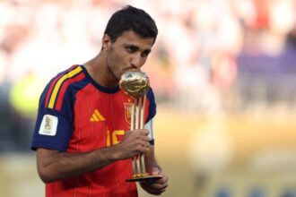 رودري يحتفل بكأس العالم ويرفع الكرة الذهبية.