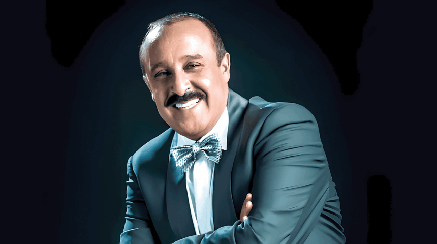 سعيد الناصري مبتسماً يرتدي نظارة وبدلة سوداء وربطة عنق
