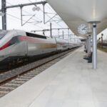 قطار فضي سريع في محطة سكك حديدية