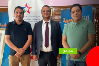 ثلاثة رجال يقفون بجانب لافتة SNRTNews.