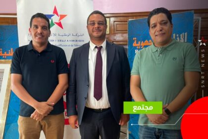 ثلاثة رجال يقفون بجانب لافتة SNRTNews.