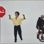 شابان يقفان بجانب علامة توقف مكتوب عليها كلمة عربية.