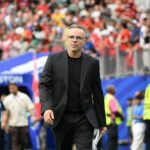 لقطة مقربة لمسؤولين يرتديان بدلات رسمية خلال نهائيات كأس العالم.
