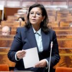 امرأة تحمل ورقة أمام ميكروفون وتتحدث