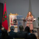 سيدة تلقي كلمة عند منصة بابتسامة