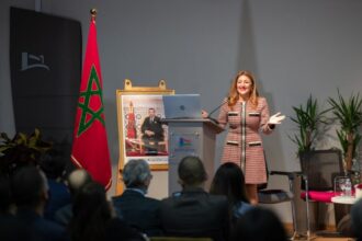 سيدة تلقي كلمة عند منصة بابتسامة