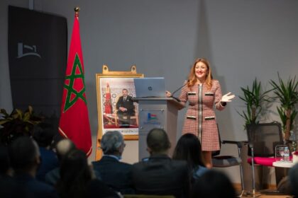 سيدة تلقي كلمة عند منصة بابتسامة