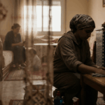 امرأة تجلس وتمسح الطاولة على ركبتيها