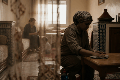 امرأة تجلس وتمسح الطاولة على ركبتيها