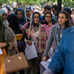 مجموعة من النساء والأمهات يقفن أمام بوابة