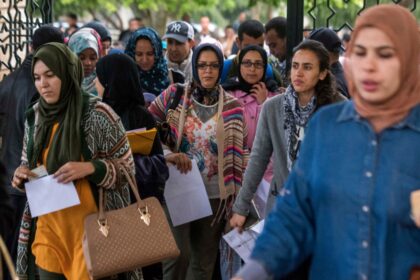 مجموعة من النساء والأمهات يقفن أمام بوابة