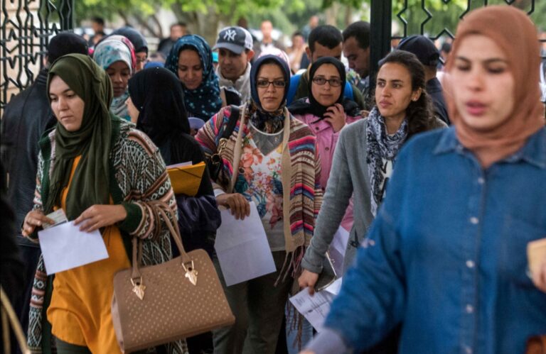 مجموعة من النساء والأمهات يقفن أمام بوابة