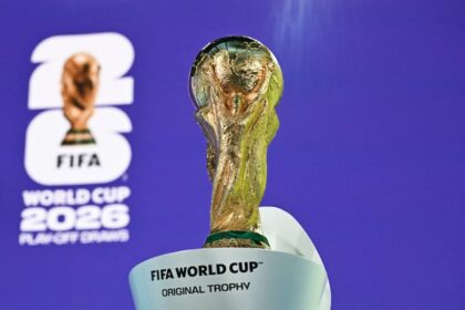 كأس العالم الذهبية تتوج على منصة بيضاء.