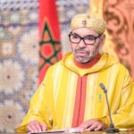 رئيس إفريقي يتحدث في ميكروفون بقاعة أنيقة