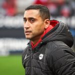 أحمد قنطاري يرتدي سترة التدريب ويقف على أرض الملعب.