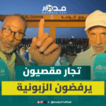 رجلان مسنان يقفان أمام بوابة سوق الواحة بمراكش