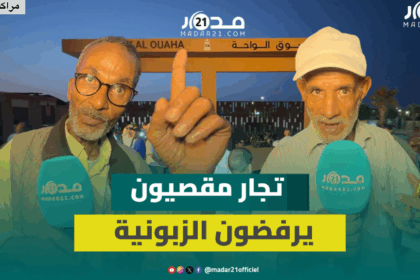 رجلان مسنان يقفان أمام بوابة سوق الواحة بمراكش