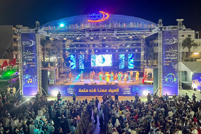 فنانون يؤدون عرضاً فنياً على خشبة المسرح أمام جمهور كبير
