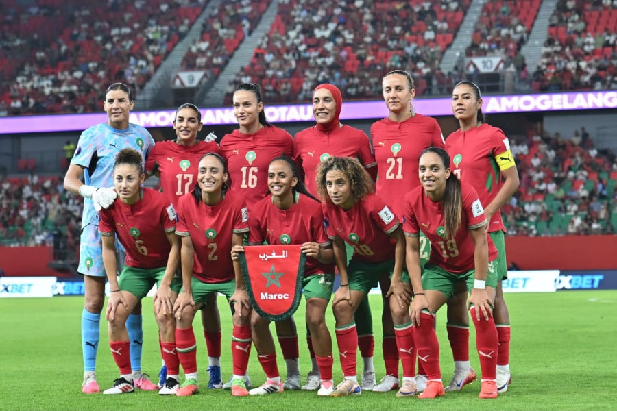 لاعبات المنتخب المغربي لكرة القدم النسوية يحملن قميص عليه شعار المغرب.