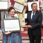 رجل يمنح جائزة لامرأة على خشبة المسرح