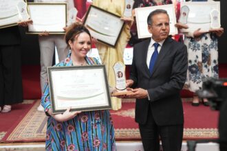 رجل يمنح جائزة لامرأة على خشبة المسرح