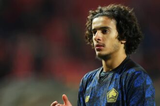 لاعب كرة قدم مغربي شاب يرتدي قميصاً رياضياً أزرق.