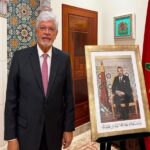 سفير برازيلي سابق يتحدث وبجواره صورة للملك محمد السادس