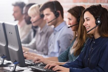 امرأة تبتسم وتعمل في مركز للاتصالات.
